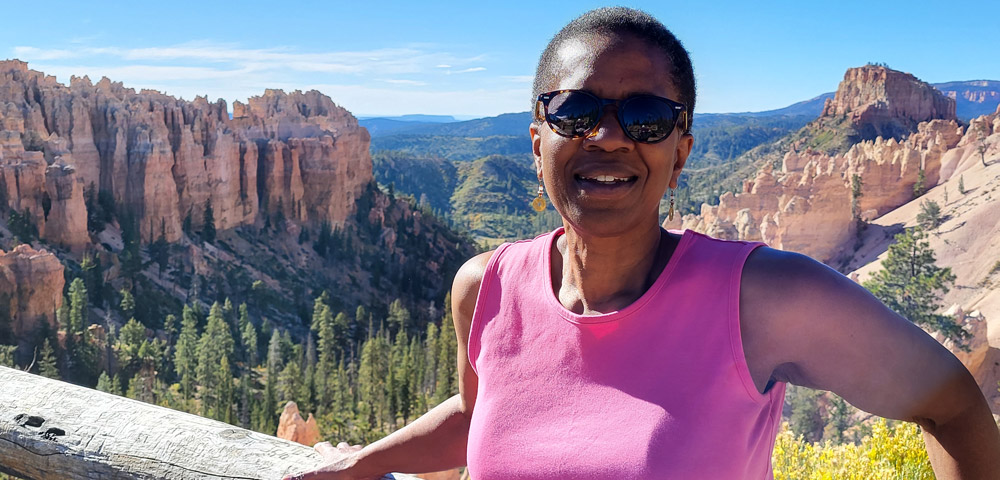 Valerie Raines at a scenic mountainous view on her post-retirement travels.